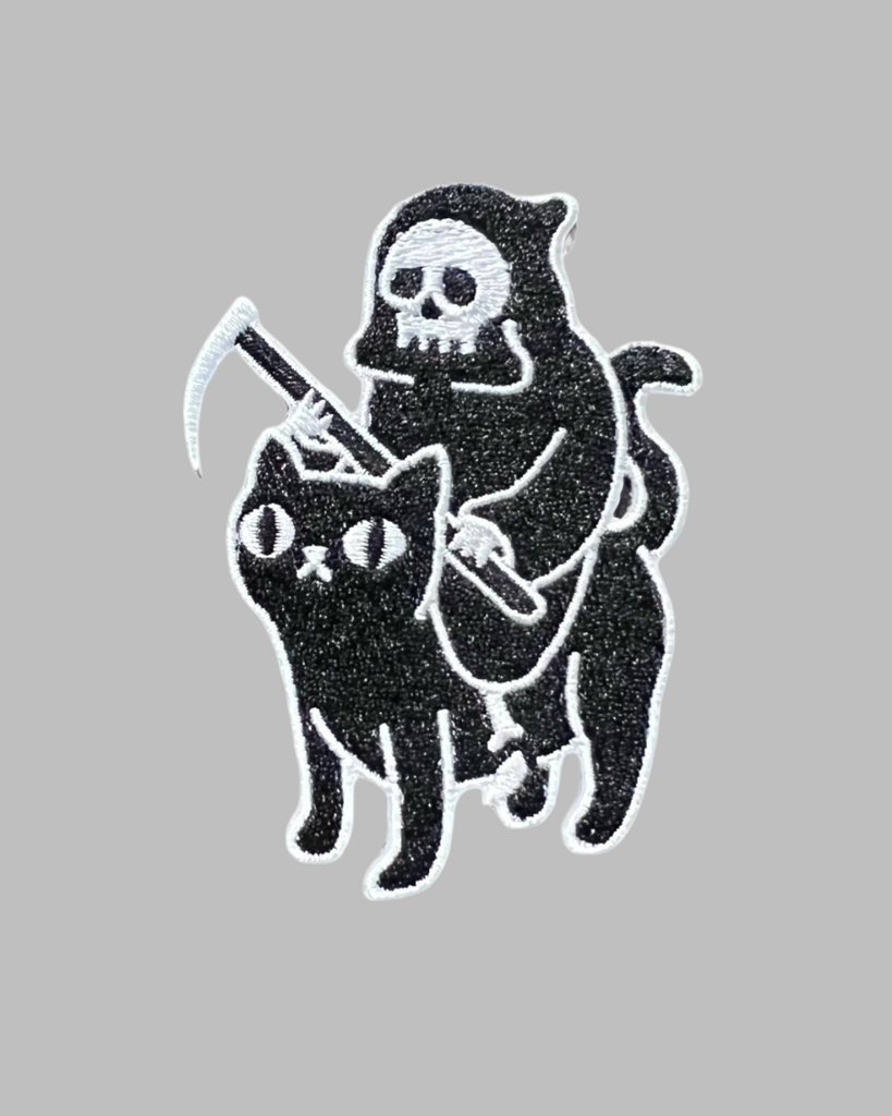 Grim reaper riding a cat black and white embroidered iron on patch sold by Le Monkey House