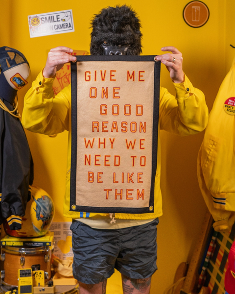 Give Me one good reason why we need to be like them camp flag Oxford